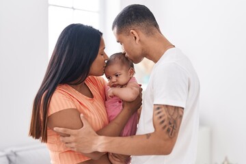 Hispanic family hugging each other kissing at home