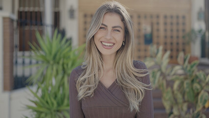 Young blonde woman smiling confident standing at street