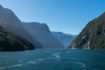 Fototapeta na wymiar Fjord mit hohen Bergen und blauem Wasser bei blauem Himmel und Sonne. 
