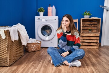 Young hispanic girl doing laundry looking stressed and nervous with hands on mouth biting nails. anxiety problem.