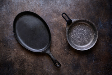 Two frying pans on a dark stone background close up, flat lay - 575072958