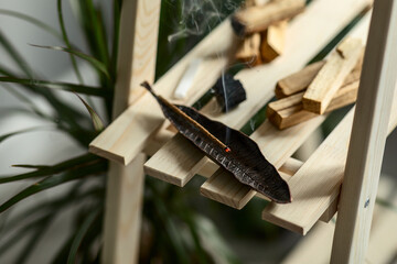 Peruvian smoke of the sacred palo santo tree. Esoteric items for meditation, anti-stress and relaxing cleansing concepts. A set for spiritual practices on a wooden shelf in the interior