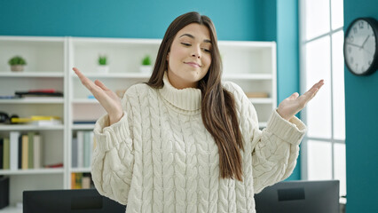 Young beautiful hispanic woman student standing with i dont know expression at university classroom