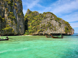 Tourist boats in the blue lagoon on Maya Bai island in Thailand
