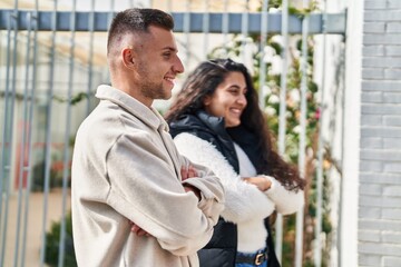 Man and woman couple standing together with arms crossed gesture at street