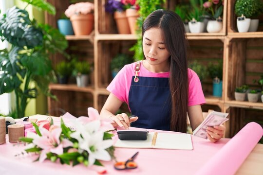 Young Chinese Woman Florist Counting Dollars At Flower Shop