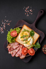 Delicious healthy lunch consisting of bacon, toast, eggs and tomatoes