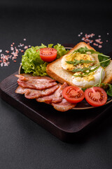 Delicious healthy lunch consisting of bacon, toast, eggs and tomatoes