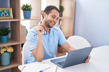 Obraz premium Young man using laptop sitting on table at home