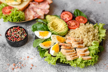 Delicious healthy lunch consisting of chicken, avocado, quinoa, eggs and tomatoes