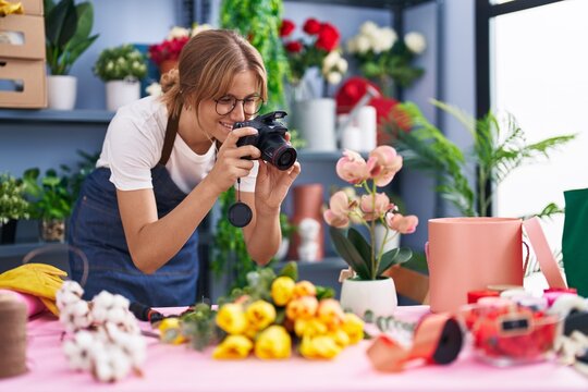 Young blonde girl florist making photo to flowers at florist