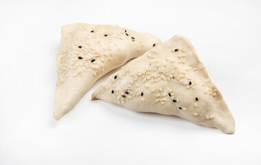 Modeling samsa with sesame seeds on a wooden board. Fresh samsa.