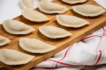 Homemade dumplings on a wooden board. Modeling.