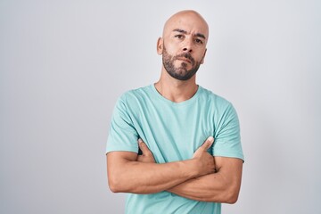 Fototapeta premium Middle age bald man standing over white background skeptic and nervous, disapproving expression on face with crossed arms. negative person.