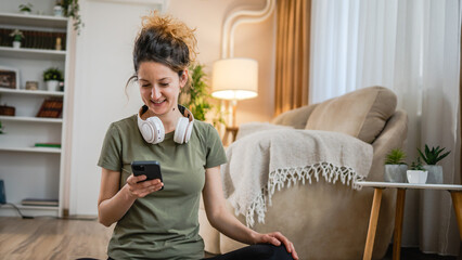 One woman sit on the floor at home with headphones and smartphone