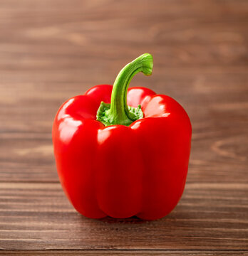 Red bell pepper on brown wooden background