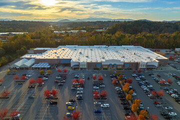 Aerial view grocery shopping mall and many colorful cars parked on parking lot with lines and...