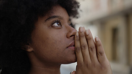 Fototapeta na wymiar African american woman praying at street
