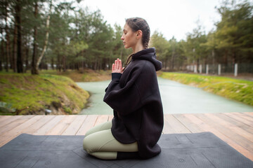 young woman doing yoga, meditation in nature