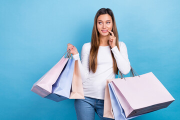 Photo of pretty dreamy woman wear white shirt holding shoppers finger lips empty space isolated...