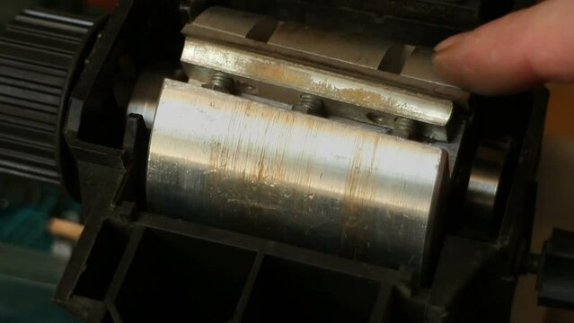 master carpenter rotates the shaft with knives of the jointer close-up