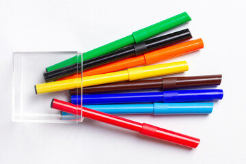 Markers of different colors lie. On a white background.