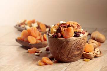 Fototapeta na wymiar Dried fruits and nuts on a beige ceramic table.