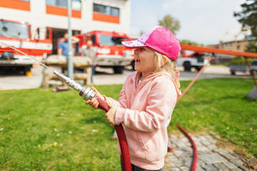 children's day with firefighters. Little girl puts out the fire.