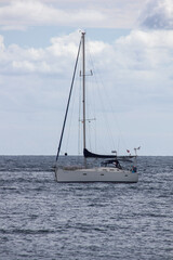 Fototapeta premium A vertical picture of a boat floating on water in the middle of an ocean