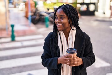 African american woman smiling confident drinking coffee at street