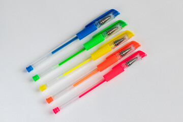 Colorful gel neon pens on white background.