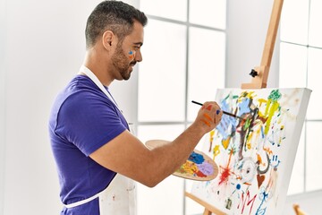 Naklejka na ściany i meble Young hispanic man smiling confident drawing at art studio