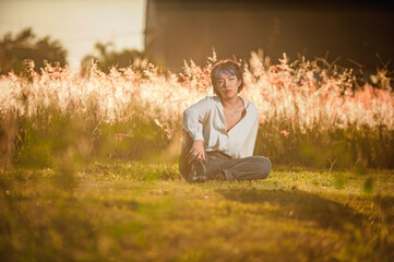 Asian young lady sitting at the outdoors flowered field.