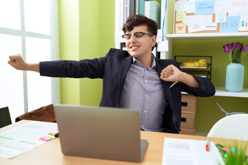 Non binary man business worker stretching arms relaxing at office
