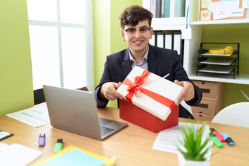 Non binary man business worker unpacking gift at office