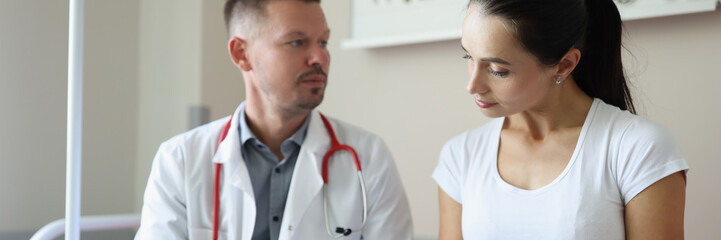 Male doctor communicates with female patient in clinic