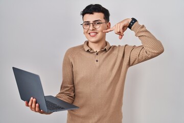 Non binary person using computer laptop smiling cheerful showing and pointing with fingers teeth and mouth. dental health concept.