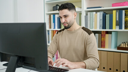 Young arab man student using computer studying at university classroom