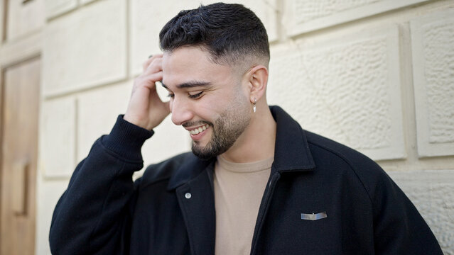 Young arab man smiling confident listening audio message by the smartphone at street