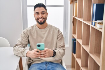 Young arab man smiling confident using smartphone at home