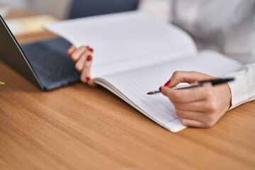 Young caucasian woman writing on notebook at office