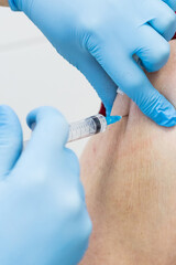 Senior woman receiving vaccine.Medical worker vaccinating an elderly patient against flu,influenza,pneumonia or coronavirus.Doctor giving Injection to senior Man at Hospital.Virus,Healthcare Concept