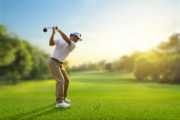 Poster Asian man golfer driver swing before hitting golf ball down the fairway. © Paitoon
