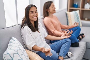 Obraz premium Two women mother and daughter doing yoga exercise at home