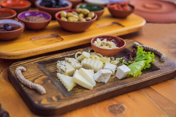 Turkish breakfast cheese. Pastries, vegetables, greens, olives, cheeses, fried eggs, spices, jams, honey, tea in copper pot and tulip glasses, wide composition