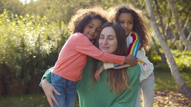Young mother with siblings daughters together having fun in city park. Realtime