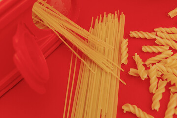 Pasta scattered on a red background