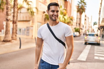 Young hispanic man smiling confident standing at street