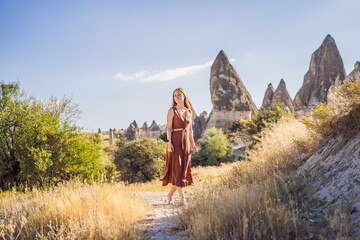 Woman tourist on background of Unique geological formations in Love Valley in Cappadocia, popular...