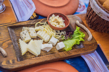 Turkish breakfast cheese. Pastries, vegetables, greens, olives, cheeses, fried eggs, spices, jams, honey, tea in copper pot and tulip glasses, wide composition